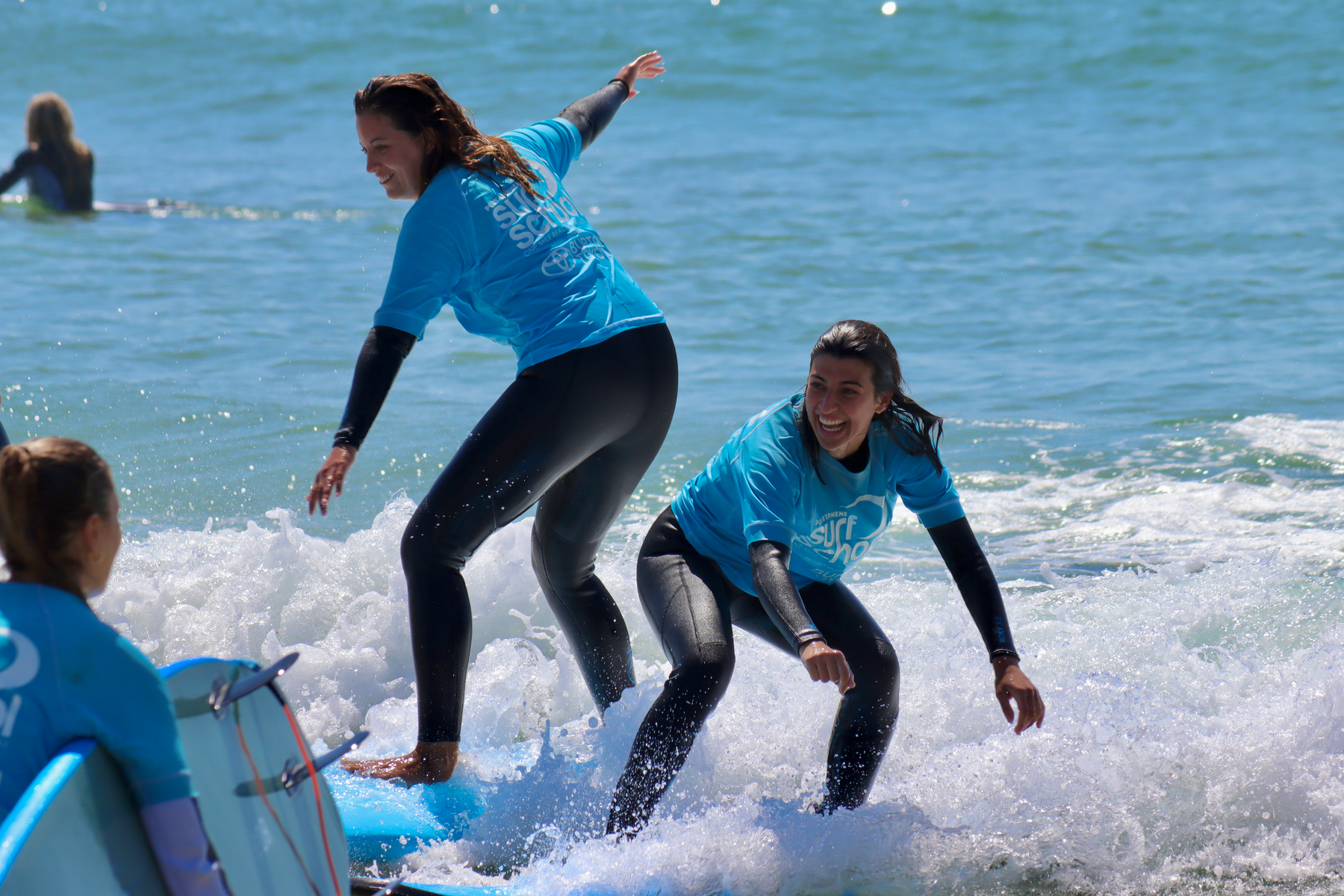 Group of surfers jumping on the sand at One Mile Beach after a Port Stephens Surf School lesson